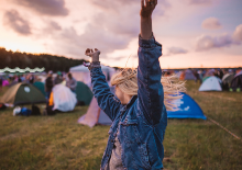 Female hands up dancing in field