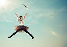 Girl jumping into blue sky