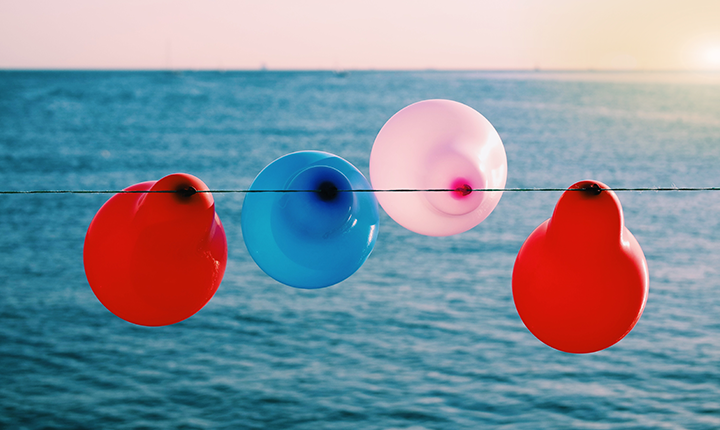 Balloons tied to a string by the sea