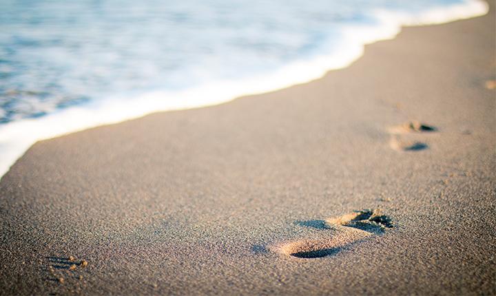 Footprints on wet sand on a beach
