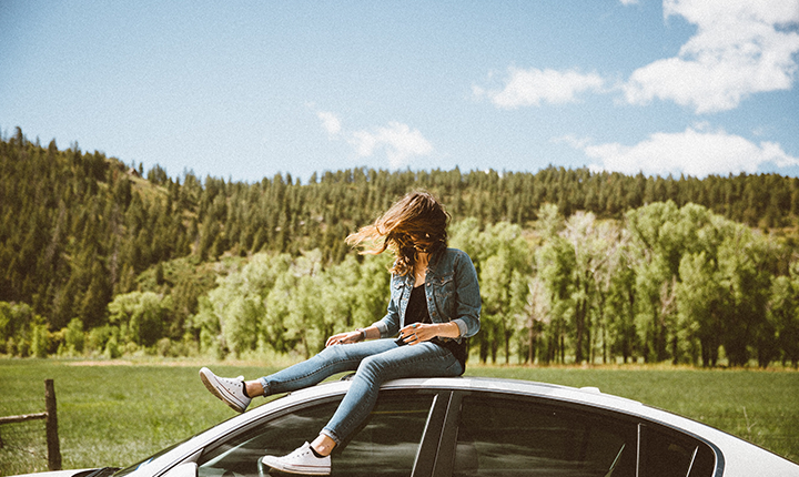 a girl sitting on a white car