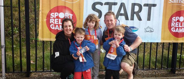 Family picture infront of Sport Relief Games banner on Barry Island