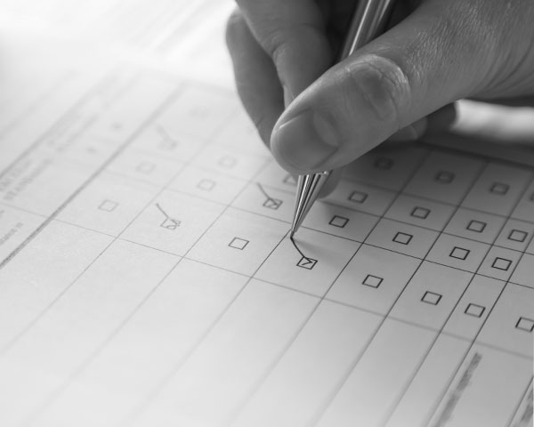 Black and white photo of someone ticking a checklist